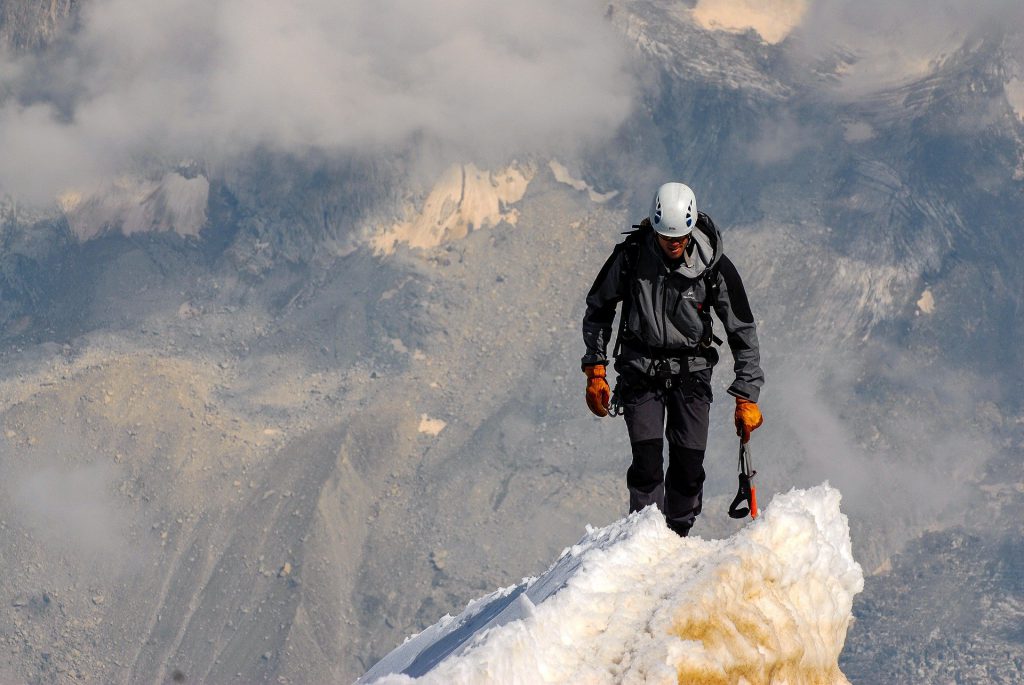 Alpinista stojący na szczycie góry. Filozofia firmy Schrag Polska - kształtowniki zimnogięte.